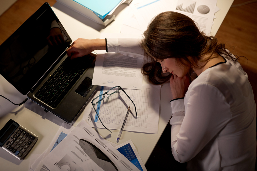 tired woman sleeping on office table at night